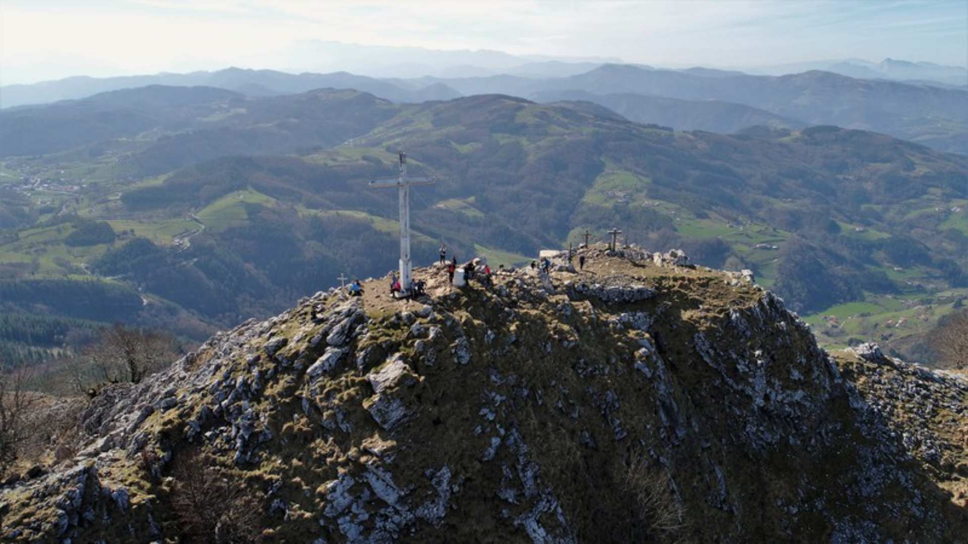Montaña con cruces y visitantes